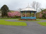 a blue and white octagonal bandstand in a park