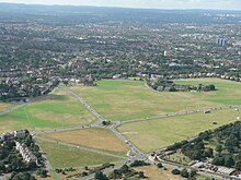 Blackheath is a minor ridge after a short dip reaching a peak at Shooter's Hill in the east; here the towers of central Lewisham and Croydon beyond to the south-west (right). The backdrop is the long crest of the North Downs in the far south of Bromley and adjoining Surrey Blackheath.jpg