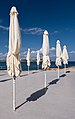 Image 891Closed patio umbrellas at a Little Armier Beach restaurant, Malta