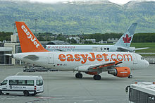 Airbus A319 de EasyJet rodando por el aeropuerto junto a una aeronave de Air Canada estacionada.