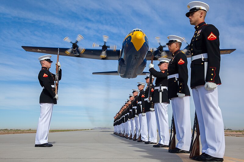 A U.S. Marine Corps C-130T Hercules aircraft with the Blue Angels, the Navy's flight demonstration squadron, flies over Marines with the Silent Drill Platoon at Marine Corps Air Station Yuma, Arizona.