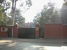 Poarta de intrare a ambasadei, păzită de un paznic.