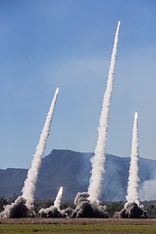 U.S. Marine Corps High Mobility Artillery Rocket Systems with 3d Battalion, 12th Marines, 3d Marine Division, and U.S. Army HIMARS with Alpha Battery, 1st Battalion, 94th Field Artillery Regiment, 12th Field Artillery Brigade, fire H185 RRPRS during Exercise Talisman Sabre 21 on Shoalwater Bay Training Area, Queensland, Australia, July 18, 2021. TS21, the ninth iteration and conducted since 2005, occurs biennially across Northern Australia. Australian, U.S. and other multinational partner forces use Talisman Sabre to enhance interoperability by training in complex, multi-domain operations scenarios that address the full range of Indo-Pacific security concerns. (U.S. Marine Corps photo by Lance Cpl. Ujian Gosun) HIMARS 3.jpg