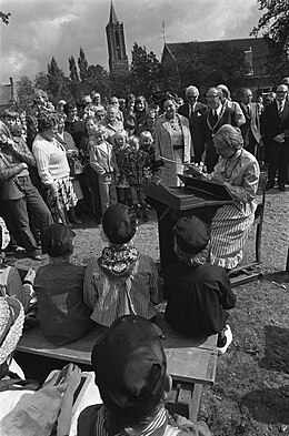 Koningin Juliana in Amerongen, 20 september 1974. Verklede kinderen zingen een lied, gedirigeerd door de onderwijzeres achter de lessenaar.