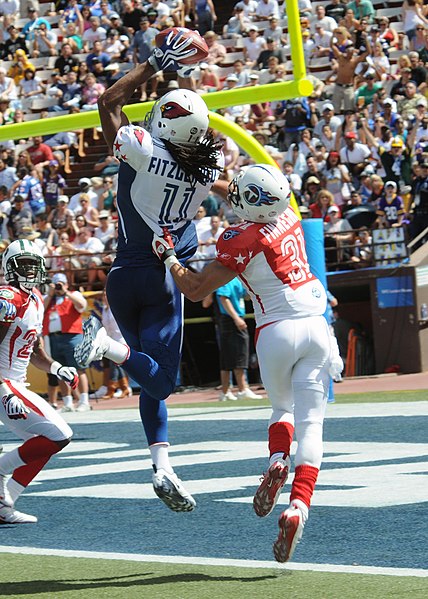 Larry Fitzgerald (in blue) catches a pass while Cortland Finnegan (in red) plays defense at the 2009 Pro Bowl.