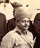 A photograph of a man with a moustache stood and wearing a turban and military uniform.