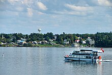 Tour boat on the Saint Lawrence River with Morristown visible on the opposite shore. This major river was named by French explorers in the 1700s to commemorate the martyred Christian Lawrence of Rome.