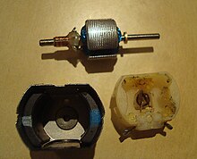 A small permanent magnet electric motor disassembled, showing the two crescent-shaped ferrite magnets in the stator assembly (lower left) Motor disassembeled.JPG