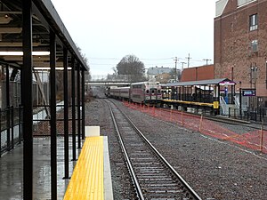 A passenger train leaving a small railway station