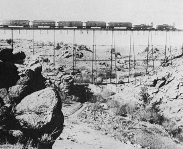 Amerika Birleşik Devletleri'nin "Vahşi Batı" denilen bölgesinde çift lokomotif tarafından çekilen tren wagonlar bir demiryolu köprüsü geçenken (1860'lı yıllarda çekilmiştir). (Üreten: Bilinmemektedir)