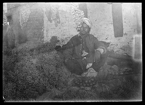 "Shopkeeper_sitting_with_his_stock_Wellcome_L0038110.jpg" by User:Fæ