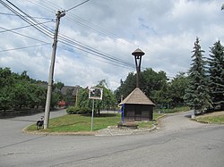 Náves s roubenou zvonicí, kopií originálu umístěného ve skanzenu v Rožnově p. R.