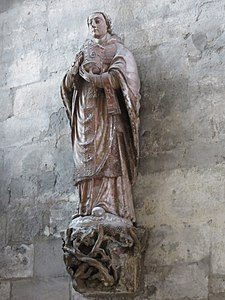 Photo de la statue de saint Nicaise polychrome sur une console en pierre sculptée de végétaux
