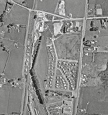 The original station was near the corner of what is now Tasman Rd and Te Kowhai Rd East. The wartime NZRAF stores base (now The Base) is at the foot of this 1961 picture. A locomotive appears to be shunting in the sidings. The new station is located slightly further south, along the NIMT. Te Rapa railway station.jpg