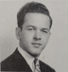 Ted Stevens in the Redondo High School Class of 1942 Yearbook. He has a dark suit, black hair, a neutral expression, and a striped tie.