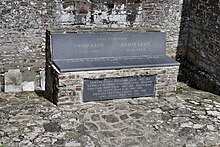 Un asiento de piedra fuera de una iglesia.