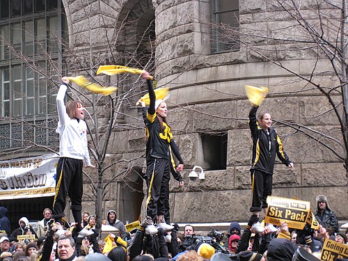 Three Steelers fans waving Terrible Towels at a Pittsburgh rally prior to the game.