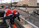 Miniatuur voor Bestand:US Navy 070722-N-4386D-001 Naval Base Kitsap, Bremerton Sailors on Delta Pier heave line in order help moor the fast attack submarine USS Seawolf (SSN 21) which transferred from Groton, Connecticut to her permanent duty station.jpg