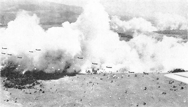5 September 1943. Dwarfed by and silhouetted against clouds of smoke generated to provide concealment, C-47s from the US Army Air Forces drop a battal