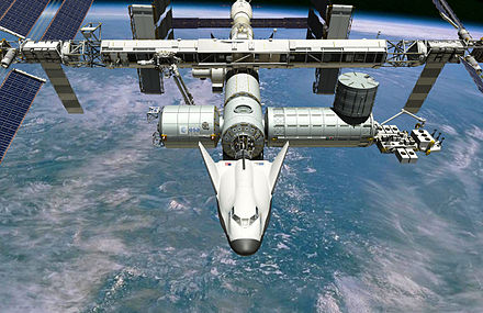 Artist's conception of the crewed Dream Chaser docked to International Space Station.