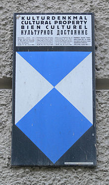 Plaque of the Bundesdenkmalamt on a building in Salzburg indicating "Cultural property" in four languages; German: Kulturdenkmal, English: Cultural property, French: Bien culturel, and Russian: Kul'turnoe dostoianie. Kulturdenkmal 4 Sprachen.jpg
