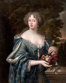 A young or middle-aged woman wearing a simple light blue dress and holding flowers.