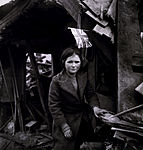 ילדה בריטית ליד הריסות ביתה שנפגע מרקטה מסוג V2. לונדון 1945.