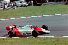 Vue latérale d'une voiture de course McLaren rouge et blanche pendant une course