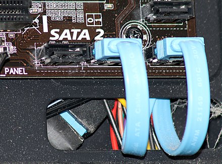 SATA 2 connectors on a computer motherboard, all but two with cables plugged in. Note that there is no visible difference, other than the labeling, between SATA 1, SATA 2, and SATA 3 cables and connectors.