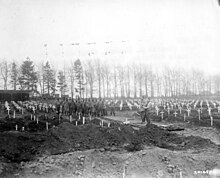 The 90th Division's military chaplain leads a field service for 3201st Quartermaster Service Company in Foy, Belgium (26 February 1945) SC 201455 - Capt. Cleetus C. Clemens, chaplain of the 90th Infantry Division, Third Army, conducts services at U.S. Military Cemetery No. 1 in Fey, Belgium, for men of the 3201st Quartermaster Service Company (53005929886).jpg