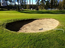 After a bunker shot a player should rake the sand smooth again Sand bunker golf.jpg