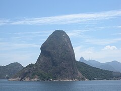 View of Sugarloaf Mountain from seaward side; Corcovado and Christ the Redeemer are seen in the background.