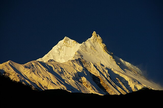 Manaslu at sunrise. The lower eastern summit appears taller due to foreshortening.