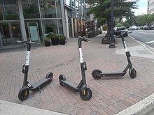 Three Helbiz scooters on a street corner in Clarendon, Arlington, Virginia Three Helbiz scooters on a street corner in Arlington 2.jpg