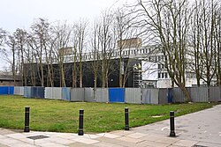 Another angle of construction work at the University of Hull's Centre of Excellence for Data Science, Al, and Modelling (DAIM) building, with construction workers unveiling the signage for the building