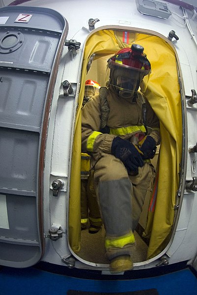 File:US Navy 070726-N-9864S-004 Seaman Robert Busch from Seattle, enters a room to fight a simulated fire during a general quarters drill aboard USS Kitty Hawk (CV 63).jpg