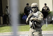 Police and Minnesota National Guard troops at the Brooklyn Center police station on April 14, 2021 A member of the Minnesota National Guard outside the Brooklyn Center Police Department on April 14, 2021 in Brooklyn Center, Minnesota. (51116675047).jpg