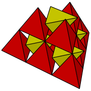移除了三角反棱柱的雙四面體堆砌。紅色為原始位於四面體-八面體堆砌中的四面體、黃色為八面體與鄰近4個四面體幾何中心形成的新四面體。空隙處正好可以放入三角反棱柱，每個四面體都與4個三角反棱柱相鄰