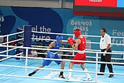 Deutsch: Boxen bei den Olympischen Jugendspielen 2018 Tag 12, 18. Oktober 2018 - Kampf um Bronze im Leichten Weltergewicht Jungen – Hassan Azim (Großbritannien, rot) schlägt Mohammed Boulaouja (Marokko, blau) RSC; Ringrichter ist Wulfren Olivares Peréz (Kolumbien). English: Boxing at the 2018 Summer Youth Olympics on 18 October 2018 – Bronze Medail Match Light Welterweight Boys - Hassan Azim (Great Britain, red) beats Mohammed Boulaouja (Morocco, blue) RSC; Referee is Wulfren Olivares Peréz (Columbia). Español: Boxeo en los Juegos Olímpicos Juveniles de Verano de 2018 en 18 de octubre de 2018 - Medalla de bronce de los hombres ligeros de peso welter: Hassan Azim (Gran Bretaña, rojo) vence a Mohammed Boulaouja (Marruecos, azul) RSC; El árbitro es Wulfren Olivares Peréz (Colombia).