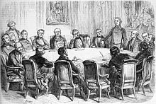 Gravure d'actualité représentant les membres de la commission électorale, assis autour d'une table ovale. Certains nous tournent le dos. Montalembert est debout à droite.