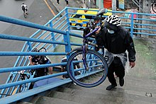 Cyclists carry their bikes on the Philcoa footbridge along Commonwealth Avenue in Quezon City (2020) Cyclists carry their bikes while using the Philcoa footbridge along Commonwealth Avenue in Quezon City on October 20, 2020.jpg