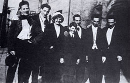 The only known photo of the entire surviving Marx family, c. 1915. From left: Groucho, Gummo, Minnie (mother), Zeppo, Sam (father), Chico, and Harpo. Early marx brothers with parents.jpg