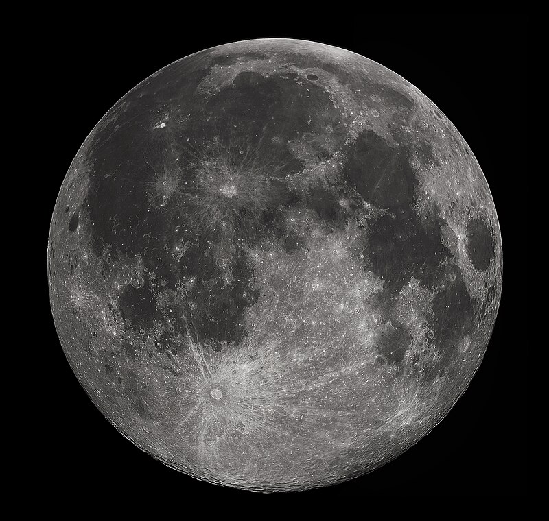 Full Moon in the darkness of the night sky. It is patterned with a mix of light-tone regions and darker, irregular blotches, and scattered with varying sizes of impact craters, circles surrounded by out-thrown rays of bright ejecta.