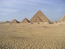 The pyramid of Menkaure in the background with the pyramids G3-a, G3-b, and G3-c in front (right to left). Gizeh Mykerinos 02.JPG