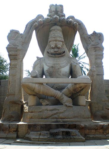Narasimha, the man-lion incarnation of Vishnu seated on the coils of Shesha, with seven heads of Shesha forming a canopy. statue at Vijayanagara.