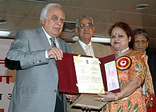 Meenu Khare receiving the National Award from Kapil Sibal. Kapil Sibal giving away the National Award for Science Communication for the year 2008 to Ms. Meenu Khare from Lucknow, for outstanding efforts in science & technology communication through electronic medium.jpg