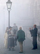 The film director gives last minute direction to the cast and crew, while filming the historical drama Sherlock Holmes and the Case of the Silk Stocking on location in London. LondonSmog.jpg
