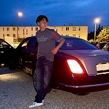 Luan steht vor einem Bentley. Dieses Bild entstand beim Video-Dreh zu der Single "So Spät" von Luan.