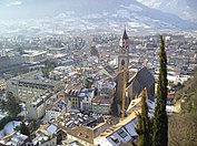 Vista del centro de la ciudad en invierno. Pueden verse las cumbres y laderas nevadas al fondo de la imagen.