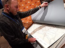 A MOX volunteer examines historic maps of Oxford Museum of Oxford volunteer with maps.jpg